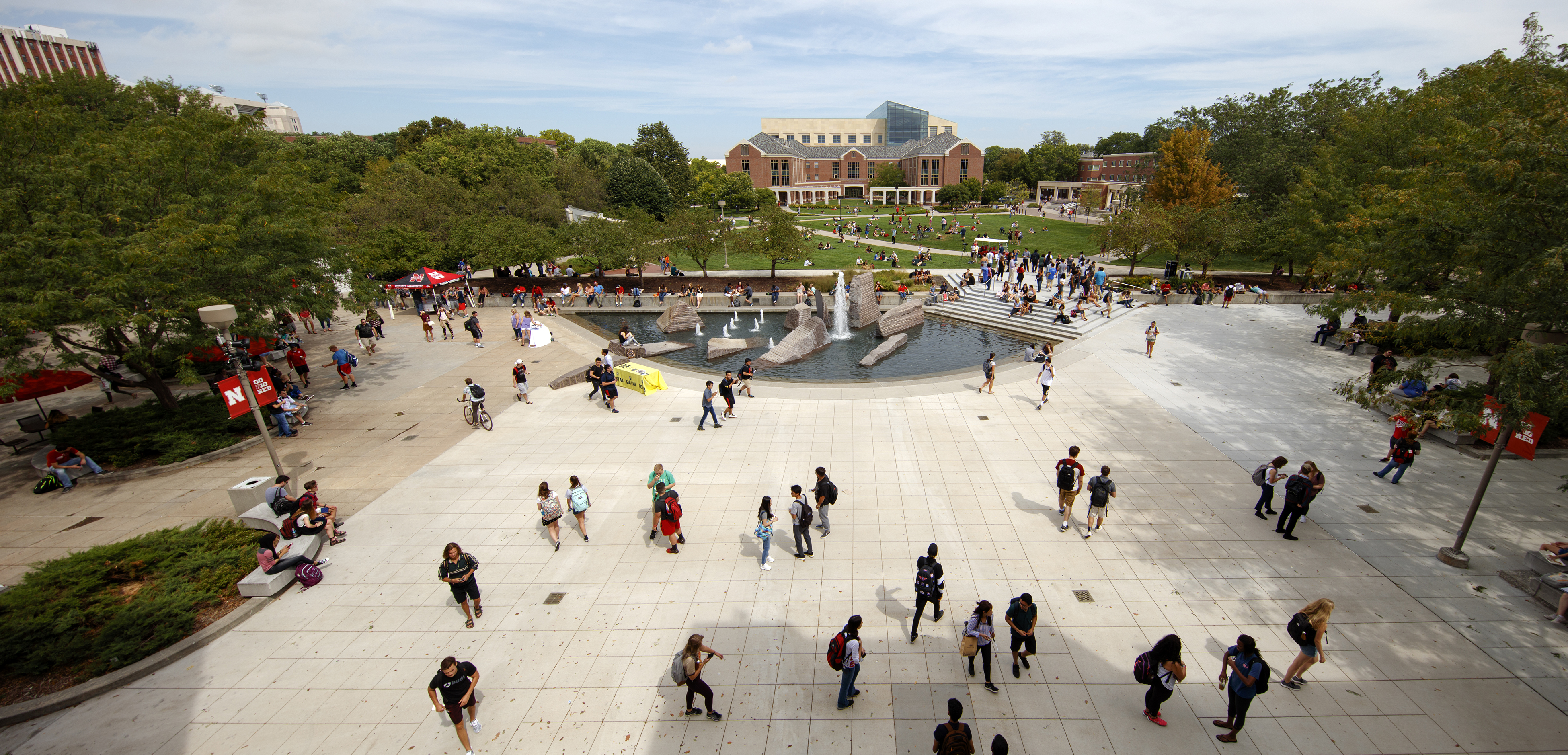 Wide shot of many student around fountain and greenspace