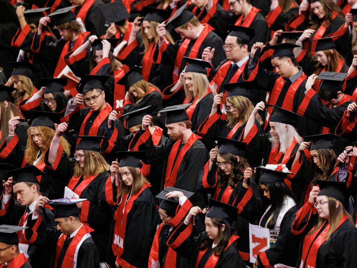 Graduates move their tassels from right to left to signify their graduation at Winter Undergraduate Commencement in Pinnacle Bank Arena