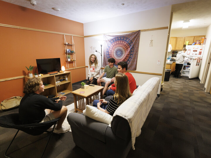 Students socializing in a University Suites Residence Hall room