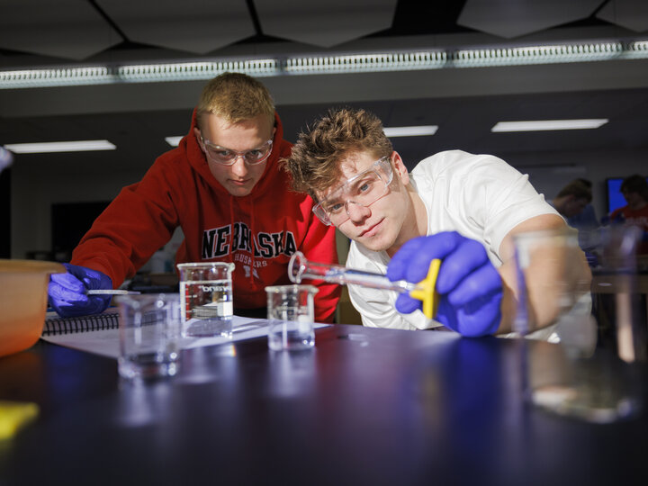 Luke Landgren dilutes a solution during a chemistry 110 lab at Hamilton Hall. Lab partner Brecken Krueger looks on.