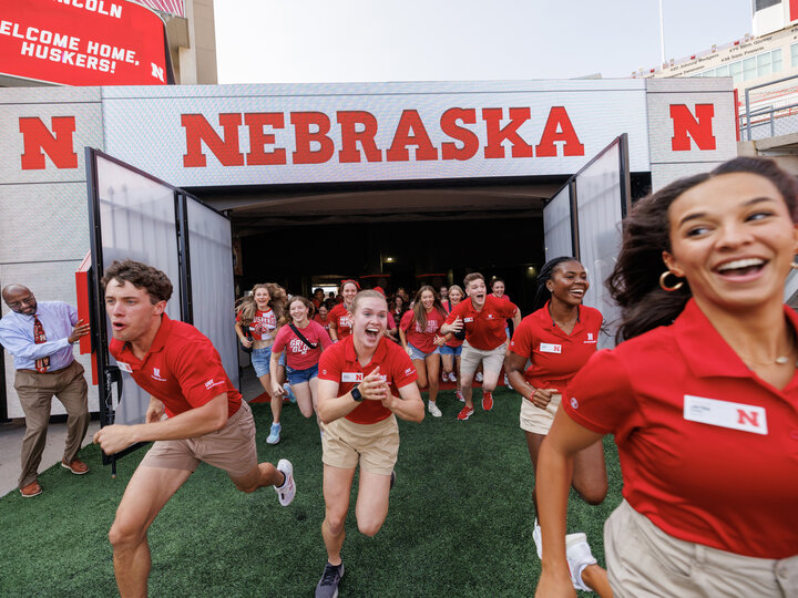 New Student Enrollment leaders including Grace Charlesworth, center, lead the Class of 2027 onto the field during the Tunnel Walk in Memorial Stadium.