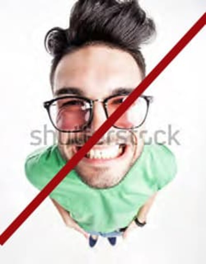 Man with cheesy smile with red line through photo