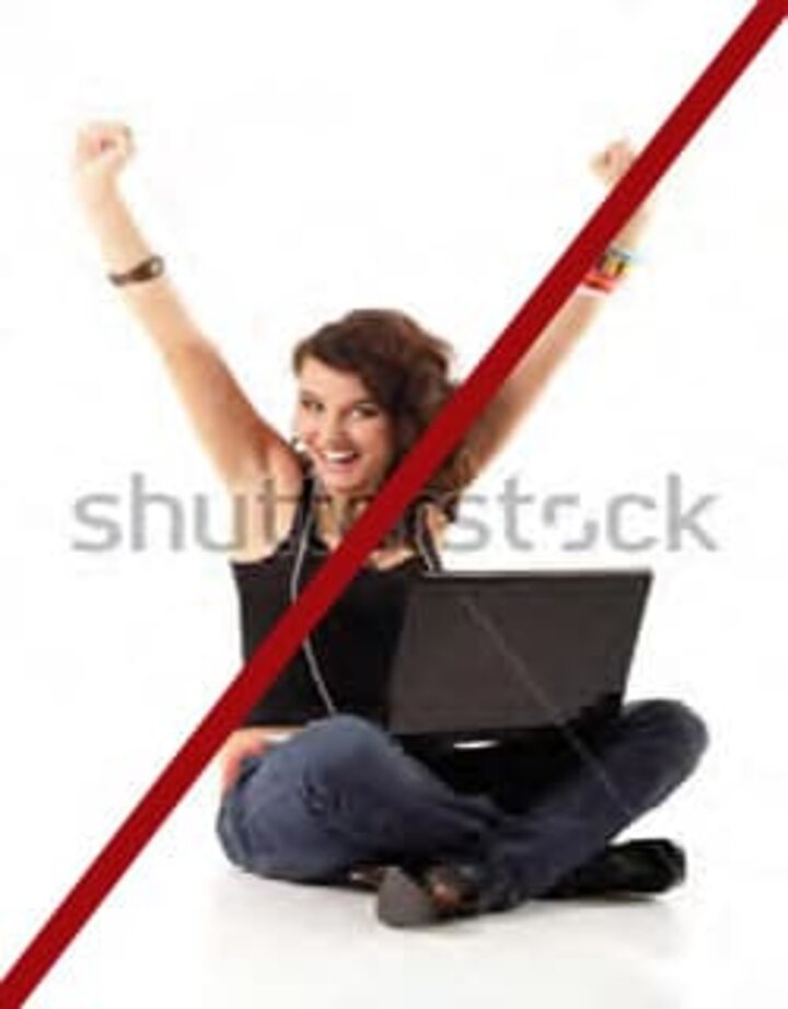 A woman sitting cross legged with laptop in lap red line through photo