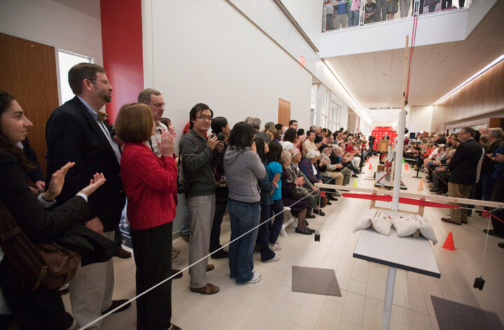 Interior of large hallway during a red ribbon cutting ceremony