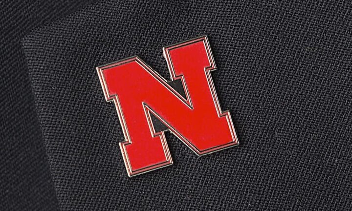 N logo lapel pin on black cloth