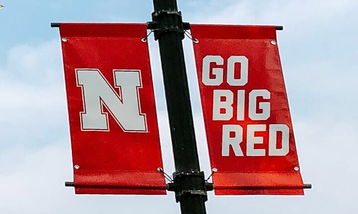 White branded pole banners on red background